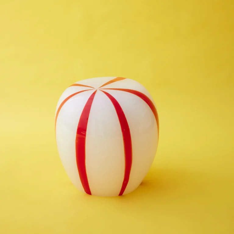 Red Candy Side Table by STUDIO BERG, white glass stool with a few wide red stripes, on a plain yellow background