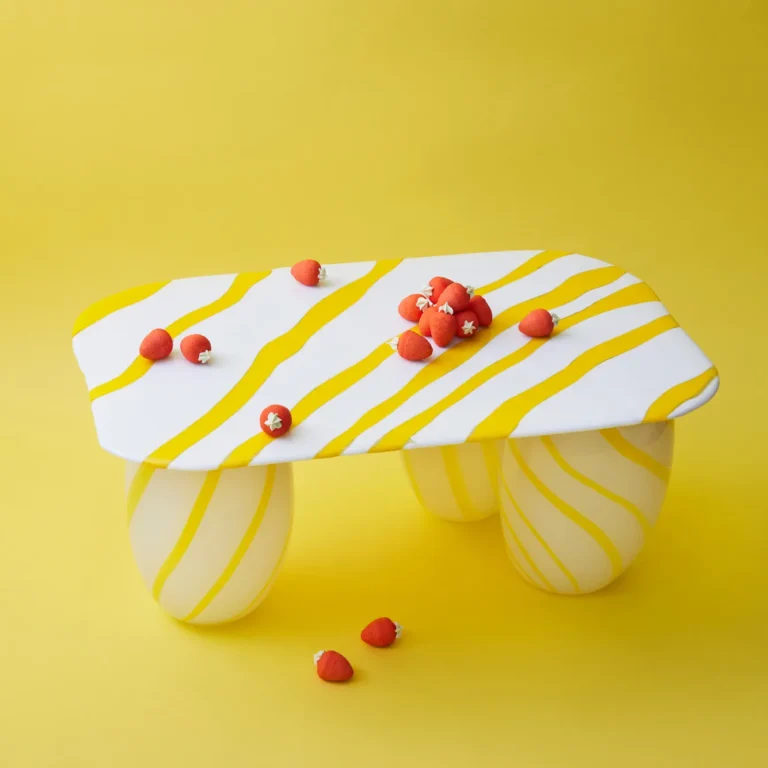 Yellow Candy Sofa Table by Studio Berg seen from above, showing the striped glass top with strawberry sweets on it