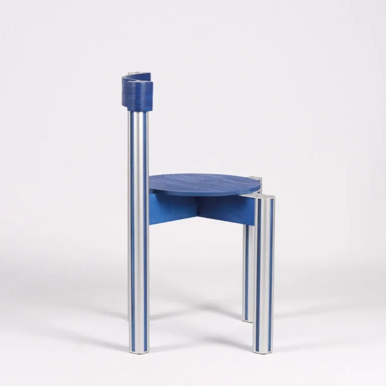 Sigma Chair by 301 Design Studio seen from the side, showing the blue round seat and slim aluminum legs