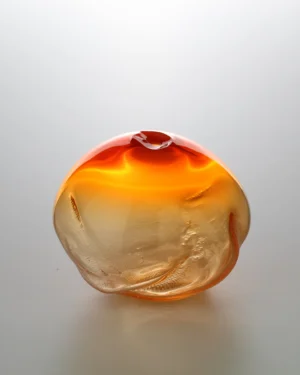 1 2 Ltr Forms Handmade Glass Object by Vogel Studio, orange blown glass with dimpled sides, on a plain background