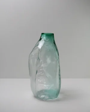 105 Ltr Forms by Vogel Studio, green blown glass vase with a dented, irregular body, on a plain background