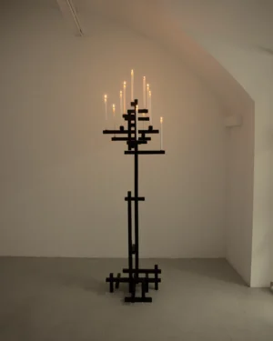 Tetris No. 11 by Studio von Schoenebeck in a white vaulted room, black burnt wooden candle holder with lit white candles