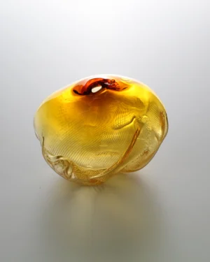 1 2 Ltr Forms by Vogel Studio, gold blown glass object with an amber top, on a plain background