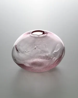 1 2 Ltr Forms by Vogel Studio, light pink blown glass object with a dimpled textured surface, on a plain background