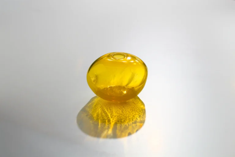 1 2 Ltr Forms by Vogel Studio seen from above, yellow glass casting a textured golden shadow on a pale surface
