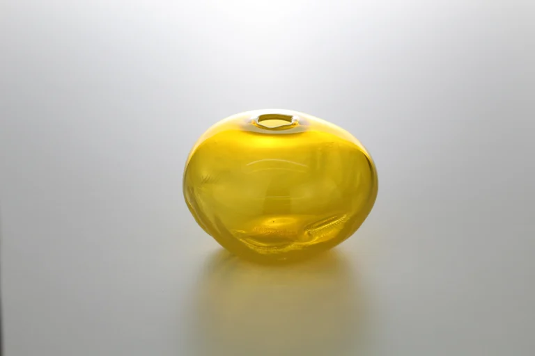 1 2 Ltr Forms by Vogel Studio seen from another side, rounded yellow glass with soft dents and a small opening