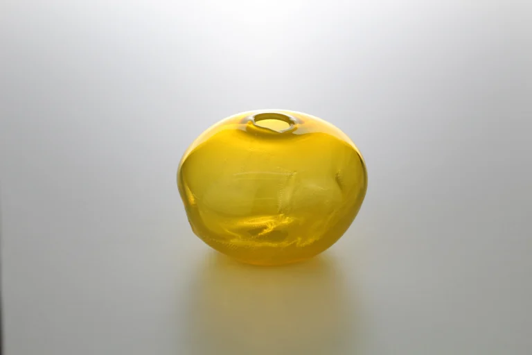 1 2 Ltr Forms by Vogel Studio, third view of the yellow glass object showing uneven dimples across its surface