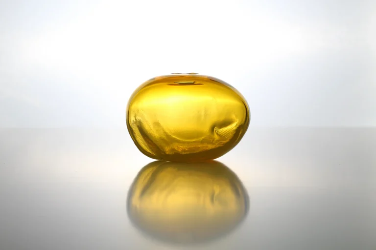 1 2 Ltr Forms by Vogel Studio at eye level, deep amber yellow glass form reflected in a glossy surface below