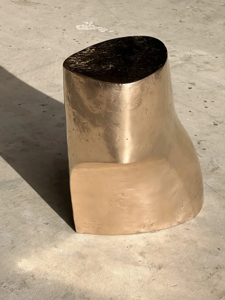 Palm Table I by Vogel Studio seen from the front, the bronze side table's flat curved face and dark top