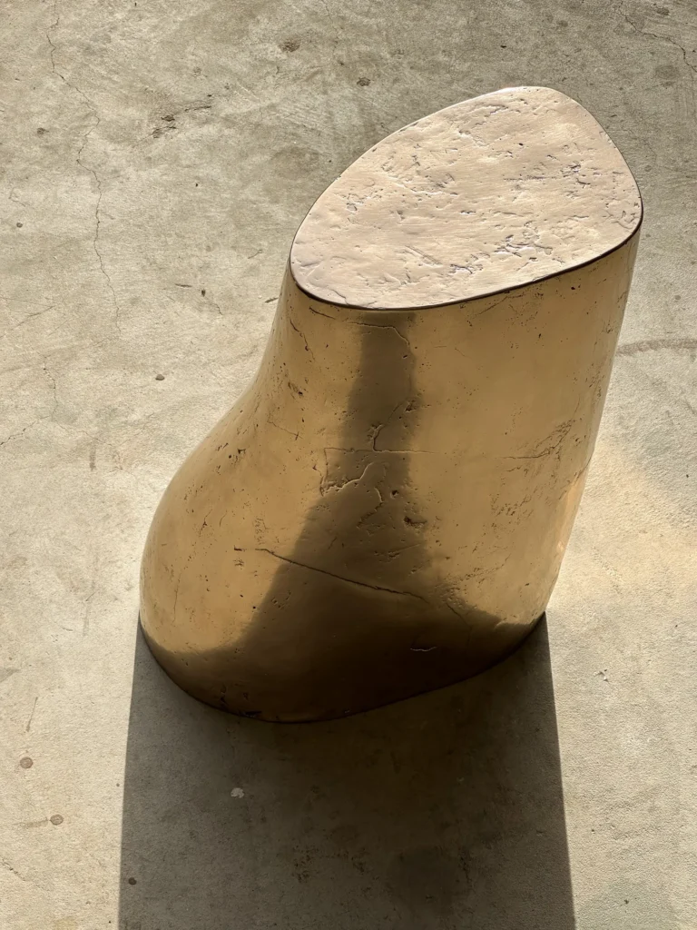 Palm Table I by Vogel Studio seen from above, showing the textured bronze top and a shadow across its side