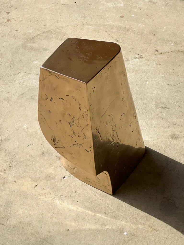 Palm Table Il by Vogel Studio seen from above at an angle, with the flat top, hand-worked surface and notch in the base
