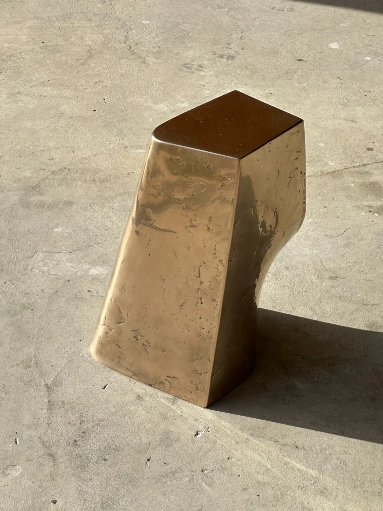 Palm Table Il by Vogel Studio seen from above and the front, showing the flat bronze top and textured, tapering sides