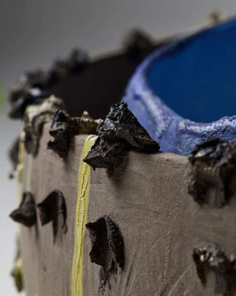 Close-up of the New_love_08 Ceramic Vase's sharp black clay peaks along the rim, with a yellow stripe and blue interior