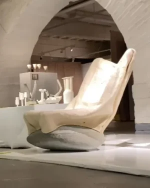 85kg Rocking Chair by Danik Uderbekov in an arched gallery space, felted wool seat on a grey stone base beside a table
